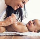 Mother changing diaper to toddler
